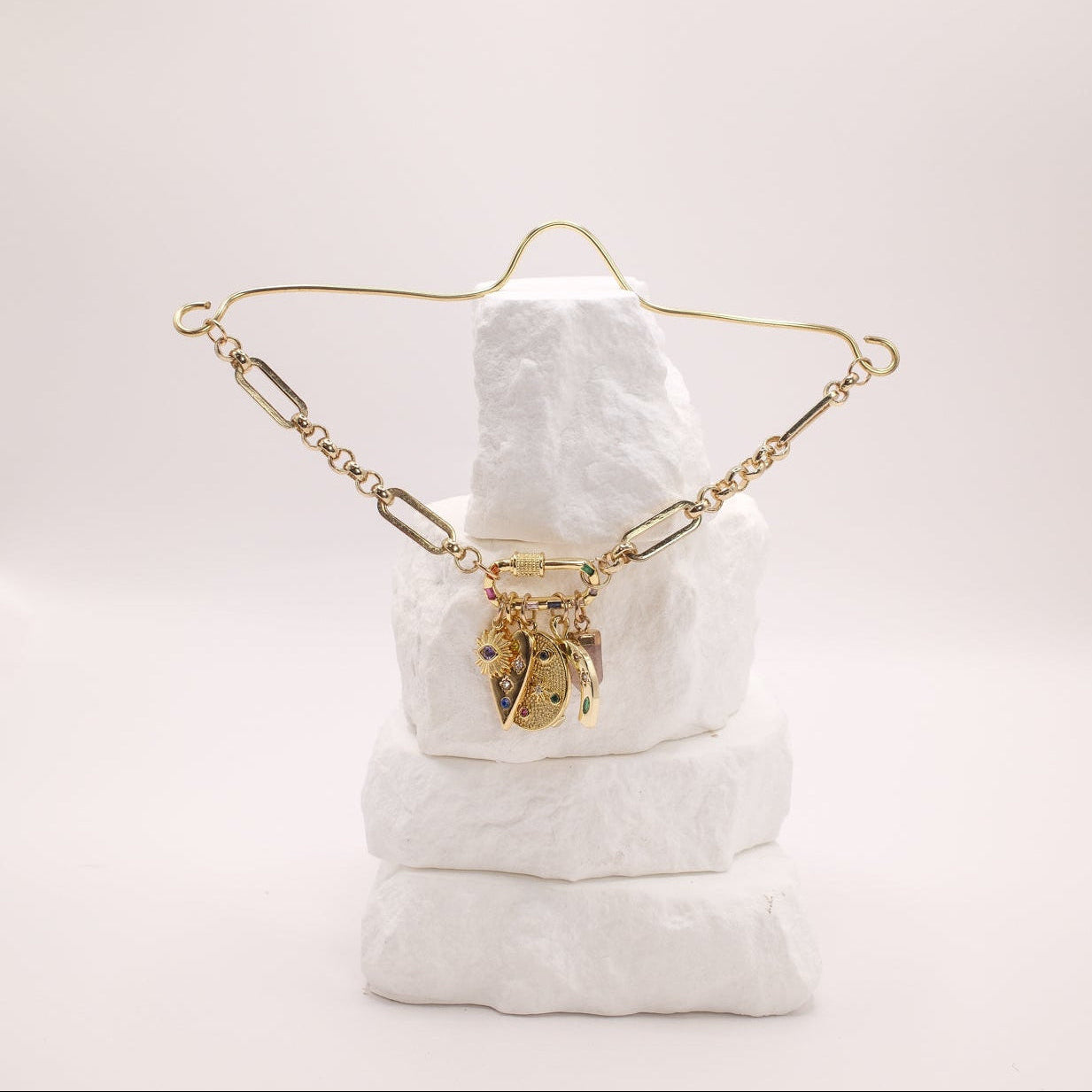 Gold rearview mirror charm on a white cushion with a plain background