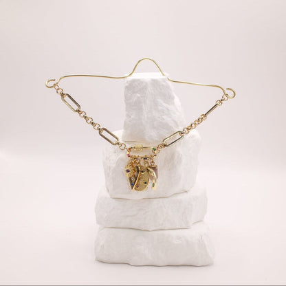 Gold rearview mirror charm on a white cushion with a plain background