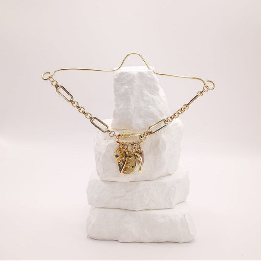 Gold rearview mirror charm on a white cushion with a plain background