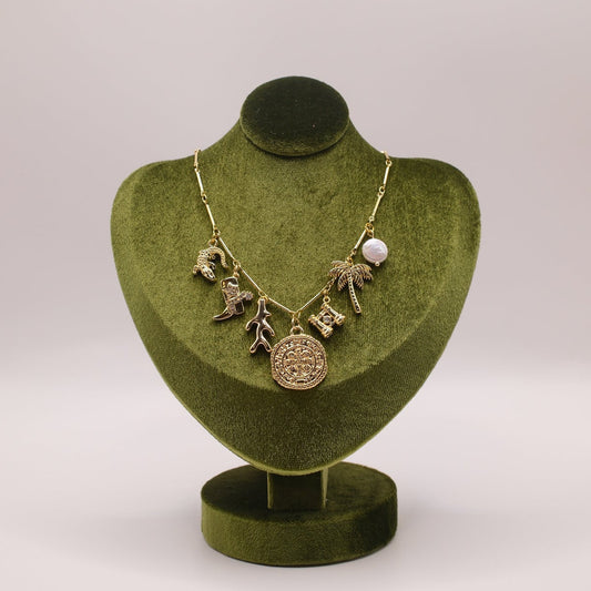 Necklace on a green velvet mannequin bust against a white background